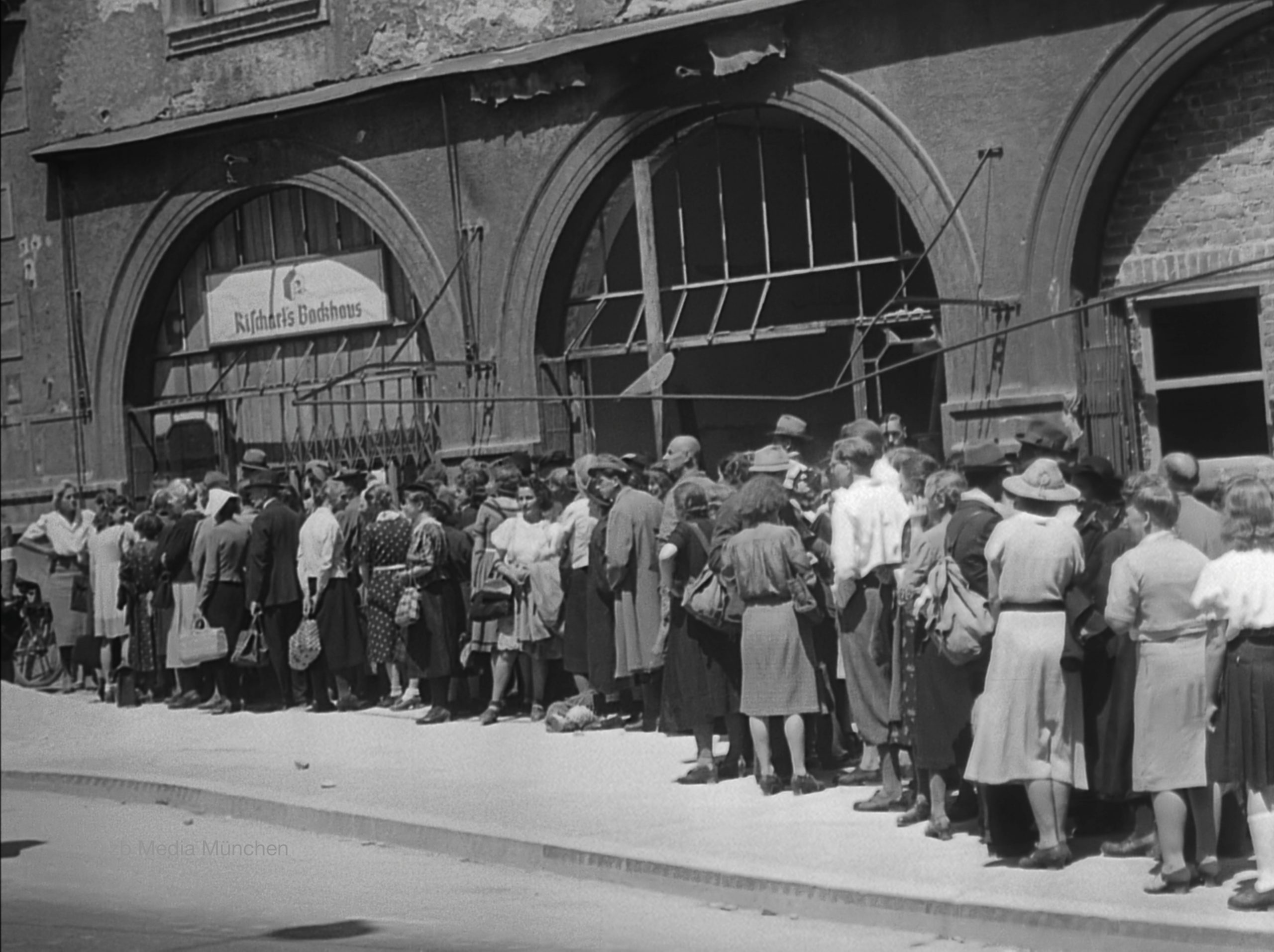 Münchner Bürger stehen um Brot an. Bäckerei Rischart, Marienplatz, München 5. Mai 1945