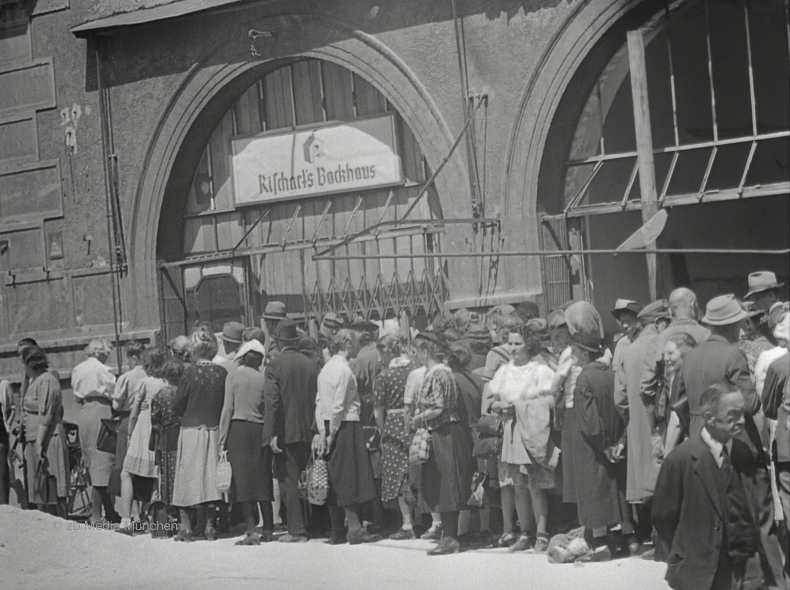 Münchner Bürger stehen um Brot an. Bäckerei Rischart, Marienplatz, München 5. Mai 1945, close